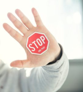 hand with a stop sign signifying danger